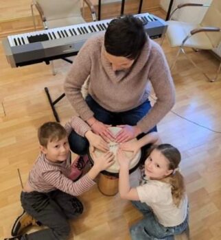 Nauczycielka i dzieci grają na bębnach