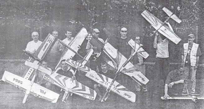 Zdjęcie z gazety- grupa chłopców z nauczycielem, trzymają modele samolotów