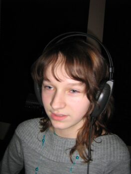 Dziewczynka w studio nagrań ze słuchawkami na uszach.