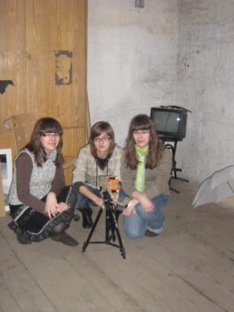 Trzy dziewczyny podczas zajęć fotograficznych. Przed nimi jakis dziwny sprzęt.