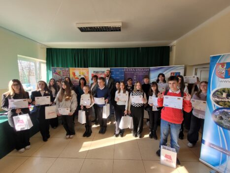 Grupa młodzieży z dyplomami i nagrodami.