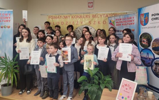 Grupa młodych ludzi z dyplomami i nagrodami.