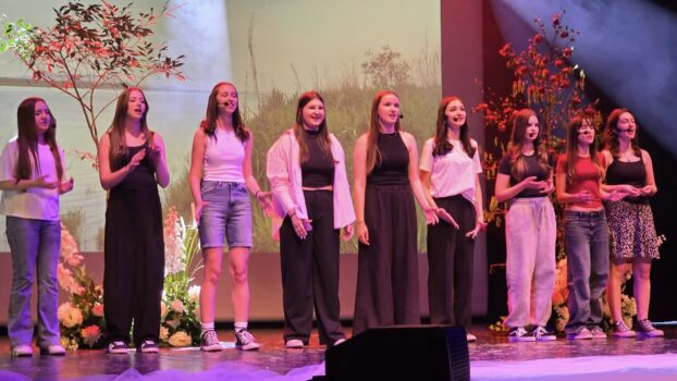 Grupa wokalna podczas musicalu na scenie - śpiewa.