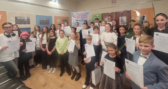 Duża grupa młodzieży zz dyplomami.