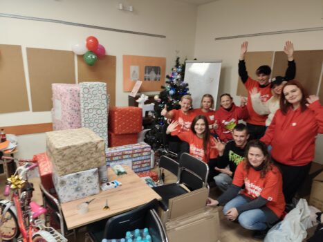 Grupa wolontariuszy Szlachetnej paczki przy prezentach podczas akcji.