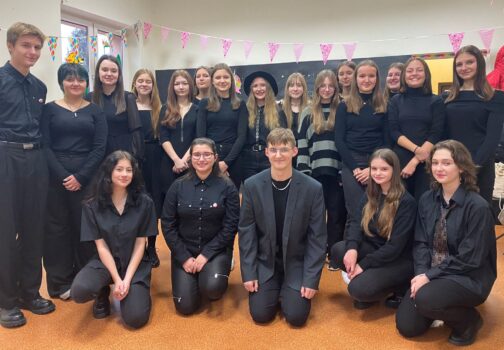 Młodzież występująca na scenie, śpiewająca.