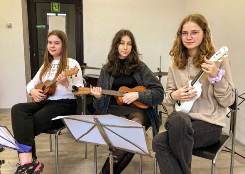 Młodzież podczas zajęć nauki gry na ukulele.