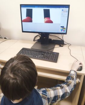 Dziecko wykonuje projekt graficzny przy komputerze.