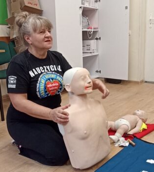 Instruktor pierwszej pomocy podczas wykładu wraz z fantomem ćwiczebnym.