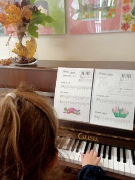 Dziecko podczas zajęć nauki gry na pianinie.