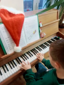 Dziecko podczas zajęć nauki gry na pianinie.