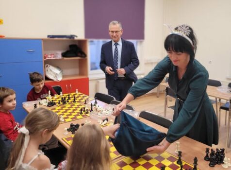 Zajęcia nauki gry w szachy. Na zdjęciu instruktor oraz pomocnica Mikołaja rozdająca mikołajkowe upominki.