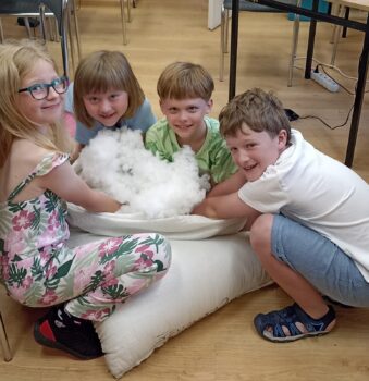 Dzieci podczas zajęć szycia na maszynie.