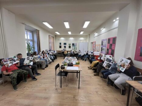 Warsztaty grupa młodzieży prezentująca swoje prace w formie posterów.