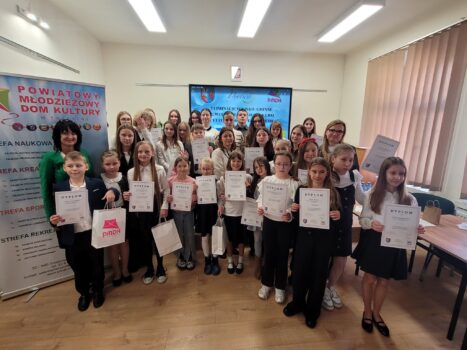 Grupa dzieci w sali odczytowej PMDK. Dzieci stoją z dyplomami.