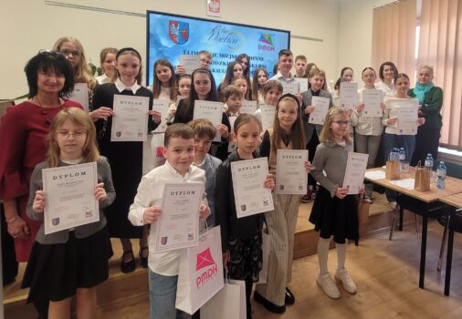 Grupa dzieci z dyplomami na sali odczytowej PMDK po konkursie.